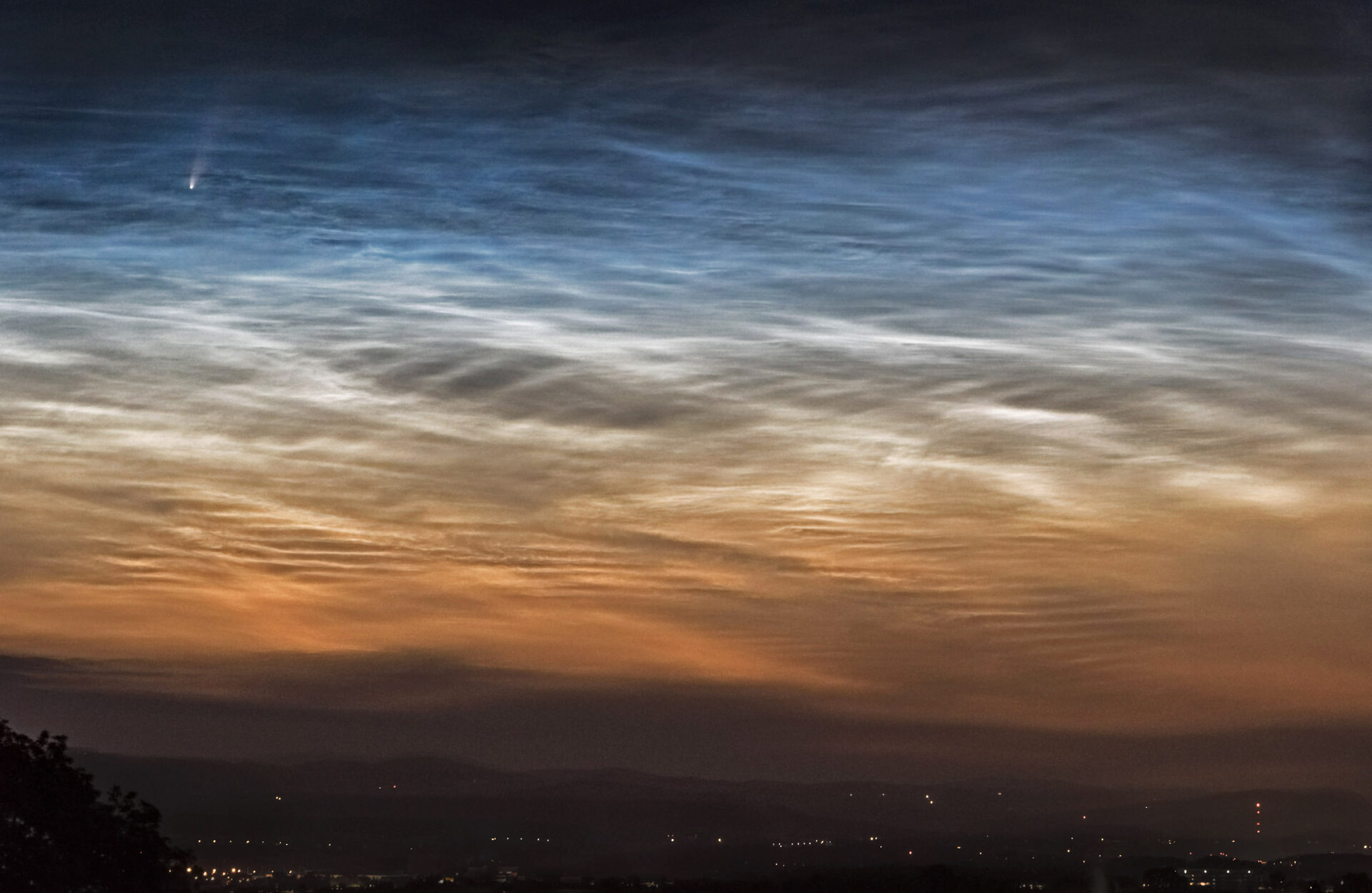 Komet NEOWISE über leuchtenden Nachtwolken